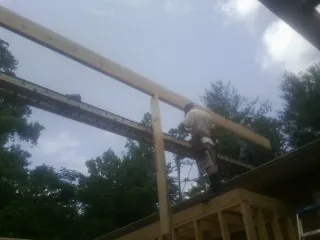 Carpenter setting a ridge beam over a new addition frame — Ice Dam Removal by Roofing Brothers in Cranberry