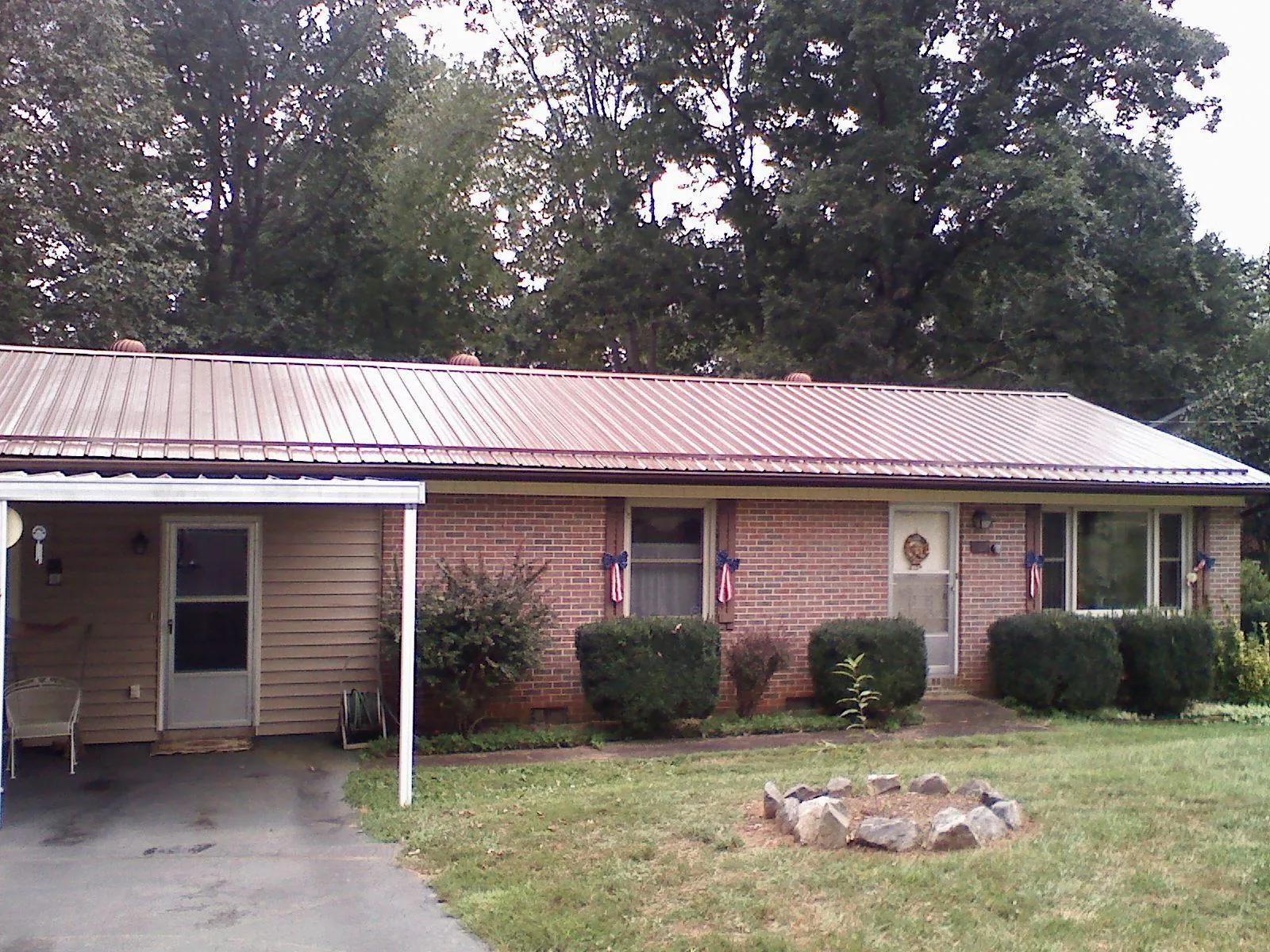 Bronze metal roof and carport on a brick ranch home — Roof Repair work by our crew in Cranberry