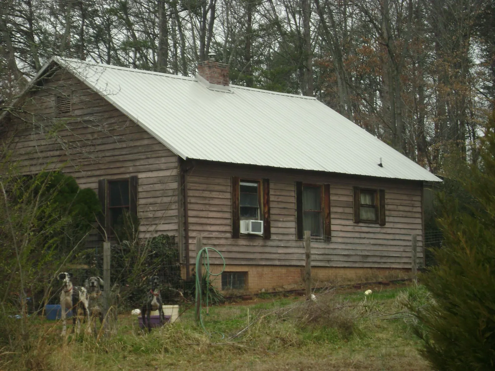 White metal roof on an old wood sided farmhouse, from a Metal Roof Installation job in Cranberry